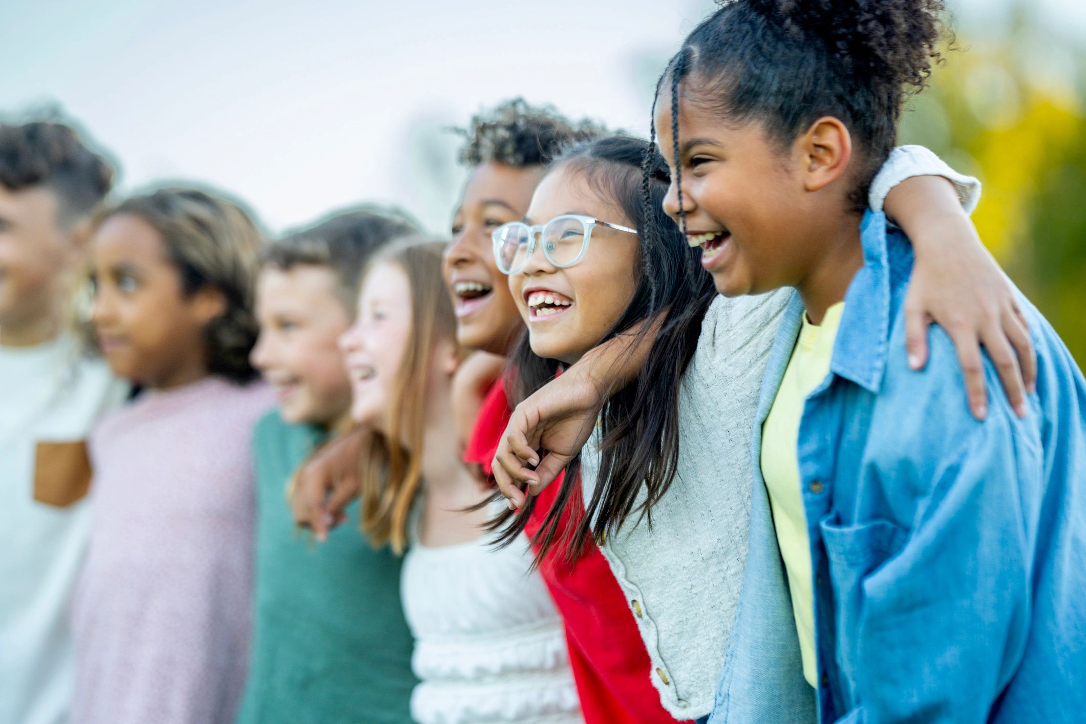 Children smiling together outdoors in a supportive community setting